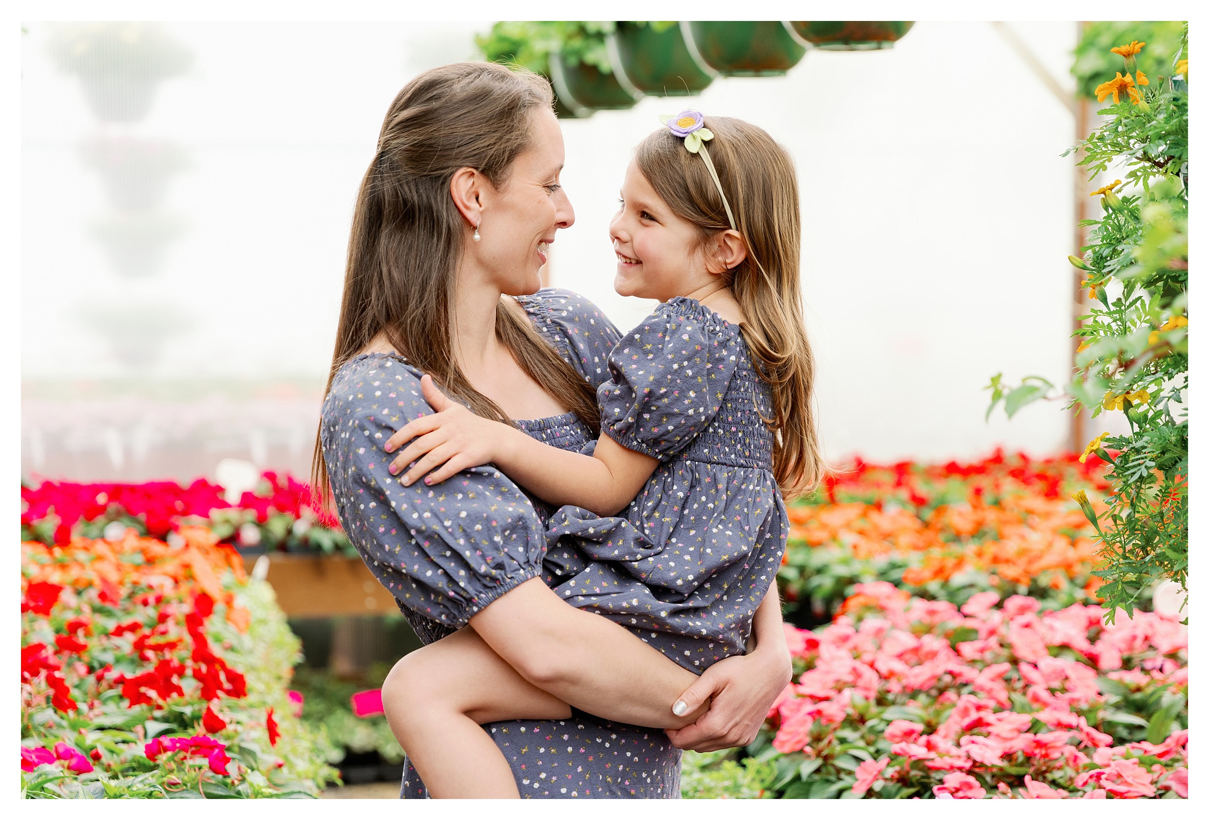 mom holds toddler girl pose in greenhouse at Rib Mountain Greenhouse