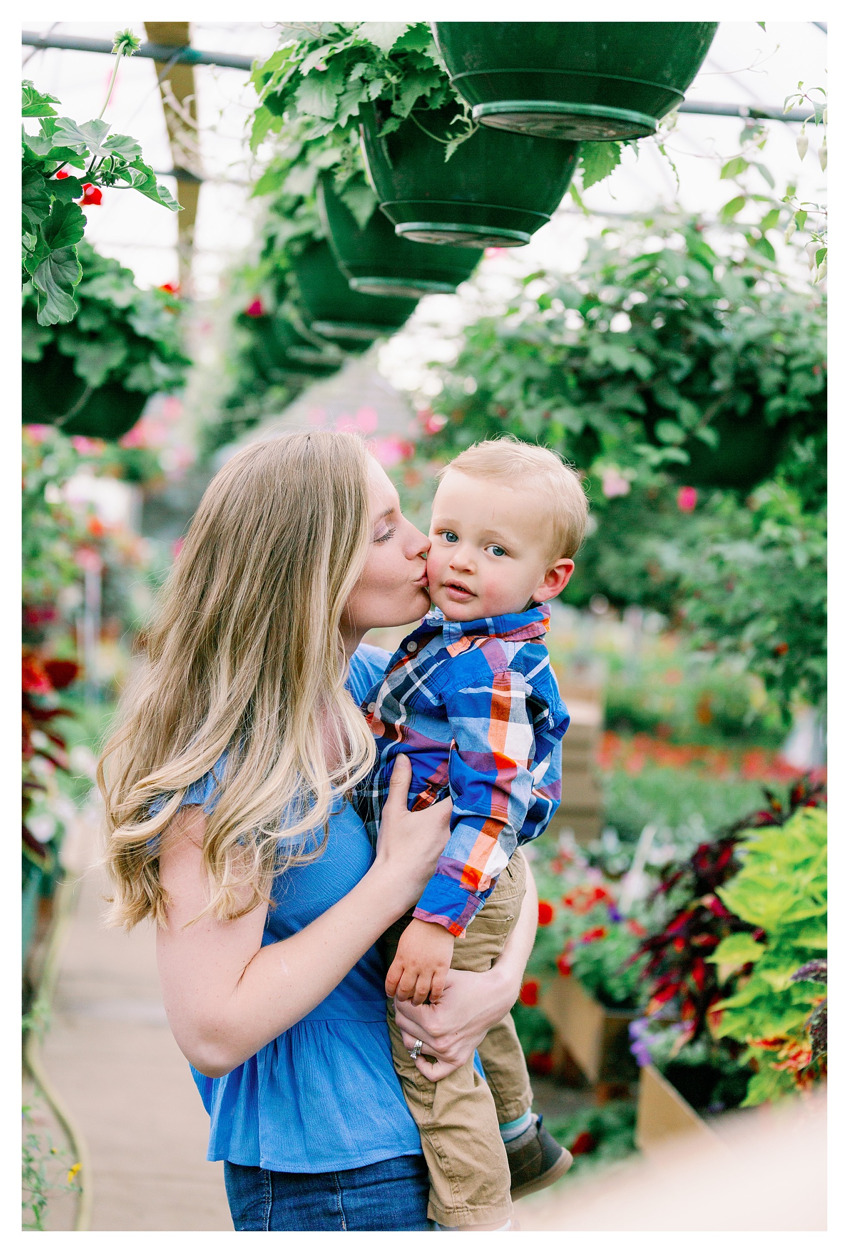 mom holds toddler boy pose in greenhouse at Rib Mountain Greenhouse