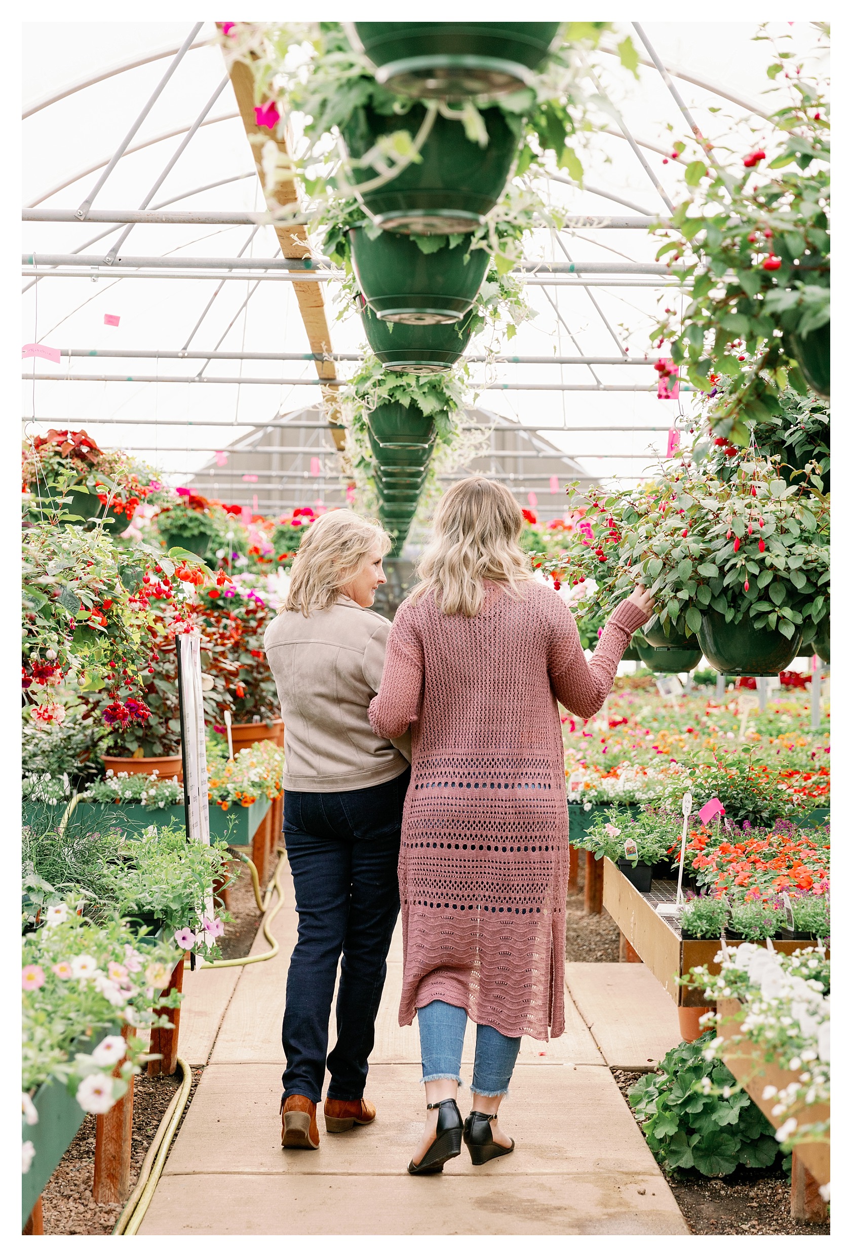 mom and adult daughter pose in greenhouse at Rib Mountain Greenhouse