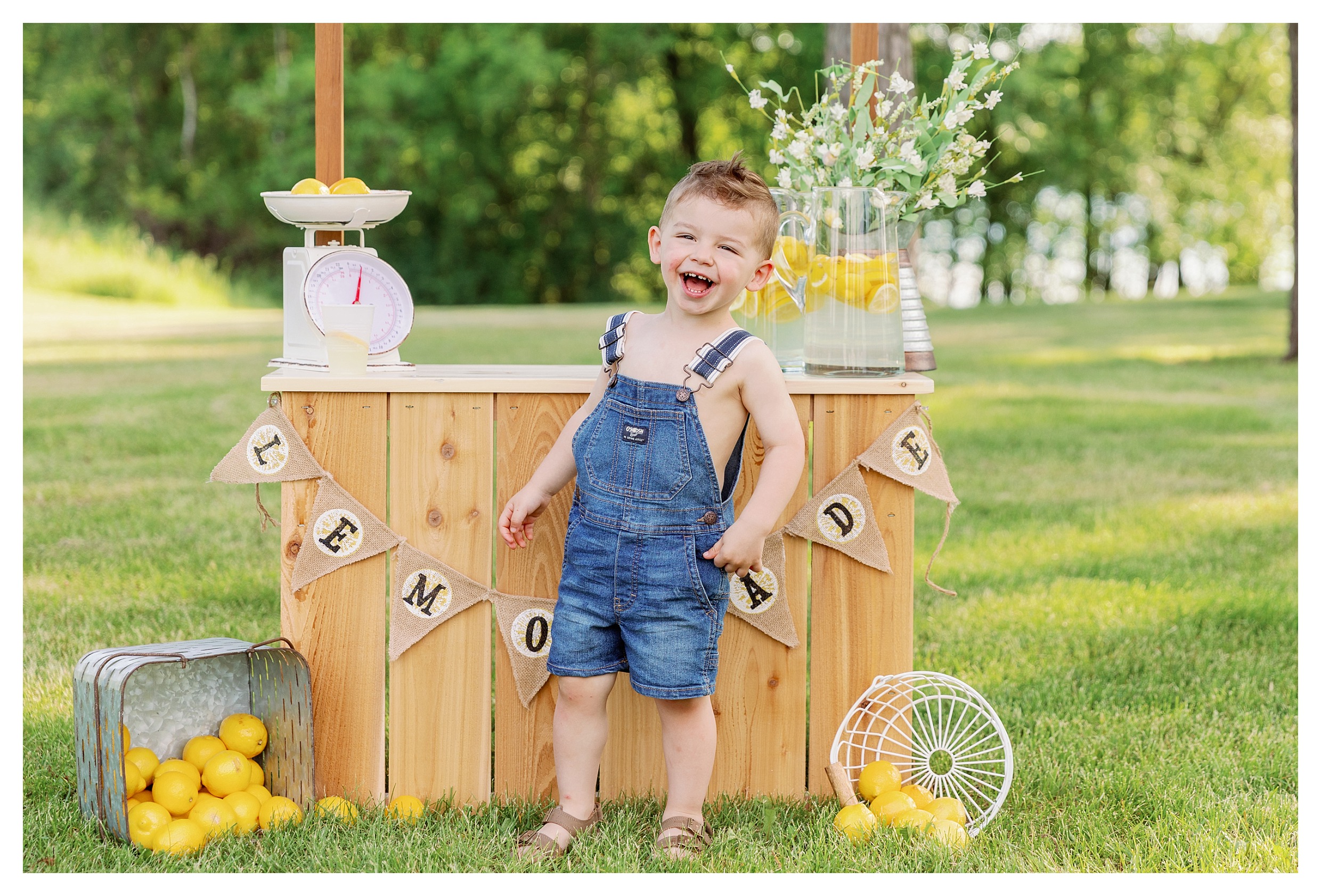 toddler boy laughs during his lemonade stand mini session 